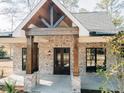 Close up of the front entrance featuring brick accents, sturdy wood pillars, and a welcoming glass door at 54 Summer Dr, Walterboro, SC 29488