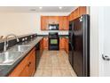 Functional kitchen boasts wood cabinets, black appliances, and ample counter space at 611 Grassy Hill Rd, Summerville, SC 29483