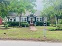 Charming home with a well-manicured lawn, mature trees, and a welcoming front porch at 647 Ellis St, Mount Pleasant, SC 29464