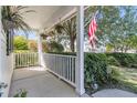 Relaxing covered front porch, adorned with hanging plants, a small fence and charming decor at 67 Regency Oaks Dr, Summerville, SC 29485