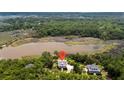 Aerial view of a community of waterfront homes nestled amongst mature trees at 8964 Palmetto Rd, Edisto Island, SC 29438