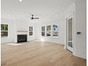 Bright living room with a fireplace, large windows, light wood floors and a ceiling fan at 100 E Carolina Ave, Summerville, SC 29483