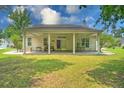 Rear exterior featuring a covered patio, ceiling fans, and a well-maintained lawn at 107 Oakbluff Rd, Summerville, SC 29485