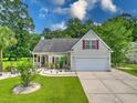 Inviting one-story home with a two-car garage and a well-kept lawn, perfect for families at 107 Oakbluff Rd, Summerville, SC 29485