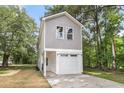 Two-story home with gray siding and white trim, featuring an attached garage and a cozy front entrance at 110 Farm Rd # A, Goose Creek, SC 29445