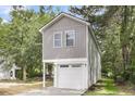Two-story home with gray siding and white trim, featuring an attached garage with stylish windows at 110 Farm Rd # A, Goose Creek, SC 29445