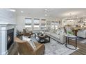 Open-concept living room showcasing stylish furnishings, a fireplace, and seamless flow to the kitchen at 111 Augusta Pass Dr, Ridgeville, SC 29472