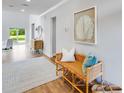 Bright entryway with a woven bench, stylish decor, wood flooring, and a view to the home's backyard at 114 Orchard Blossom Ln, Summerville, SC 29485