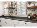 Close up of kitchen with white cabinets, stone countertops, and stainless steel range hood at 115 Winding Branch Dr, Summerville, SC 29486