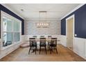 Elegant dining room featuring designer wallpaper, wood table, and stylish light fixture at 1164 Sharpestowne Ct, Mount Pleasant, SC 29466