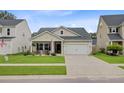 Inviting single-story home with a tidy lawn, two-car garage, and a welcoming front porch at 135 Cypress Preserve Blvd, Moncks Corner, SC 29461