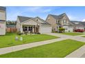 Attractive single-story home featuring a well-kept lawn, an attached garage, and a charming front porch at 135 Cypress Preserve Blvd, Moncks Corner, SC 29461