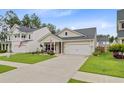 Pleasant single-story home with a tidy lawn, attached two-car garage, and cozy front porch at 135 Cypress Preserve Blvd, Moncks Corner, SC 29461