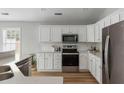 Beautiful kitchen featuring white cabinetry, stainless steel appliances, subway tile backsplash, and wood flooring at 1420 Wellesley Cir, Mount Pleasant, SC 29466