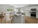 Modern kitchen with white cabinets, stainless steel appliances, quartz countertops, and barstool seating at 1420 Wellesley Cir, Mount Pleasant, SC 29466
