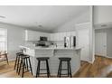 Bright kitchen features white cabinets, stainless steel appliances, breakfast bar, and stylish bar stools at 1420 Wellesley Cir, Mount Pleasant, SC 29466