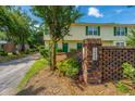 Charming townhome with yellow siding, green shutters, and a brick pillar with the house number at 1423 Ashley River Rd # 3A, Charleston, SC 29407