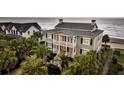 Lovely two-story home with a charming porch overlooking lush foliage and sandy beach at 210 Ocean Blvd, Isle of Palms, SC 29451