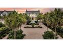 Stunning home with palm-lined drive and meticulously landscaped grounds highlighted against a beautiful sunset backdrop at 210 Ocean Blvd, Isle of Palms, SC 29451