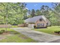 Exterior shot showcasing a long driveway leading to a two-car garage and gated entrance at 213 Turtle Point Rd, Summerville, SC 29483