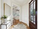 Elegant foyer with wood floors, decorative mirror, and open view to the living room at 2206 Weepoolow Trl, Charleston, SC 29407