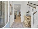 Bright entryway featuring a staircase, unique console table, and views of the kitchen and dining area at 3035 Robeson Trce, Johns Island, SC 29455