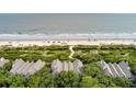 Aerial view of a beachfront home with direct access to the beach, surrounded by greenery and trees at 3560 Shipwatch Rd, Kiawah Island, SC 29455