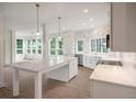 Bright, renovated kitchen featuring white cabinetry, marble countertops, and stainless steel appliances at 3560 Shipwatch Rd, Kiawah Island, SC 29455