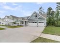 Charming light blue two-story home with a two-car garage, front porch and manicured lawn at 395 Wappoo Trace Ln, Summerville, SC 29486