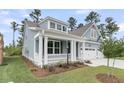Charming, light blue two-story home with manicured lawn and covered front porch at 395 Wappoo Trace Ln, Summerville, SC 29486