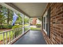 Inviting porch with brick accents, white railings, and lush landscaping adds charm to the home at 5488 Altamaha Dr, North Charleston, SC 29420