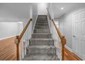 Carpeted staircase with wooden handrail, connecting the floors with an open landing at 5488 Altamaha Dr, North Charleston, SC 29420