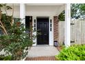 Welcoming front porch featuring a classic black door, brick accents, and manicured greenery at 655 Swinton Ct, Mount Pleasant, SC 29464