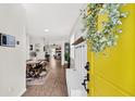 Inviting entryway featuring a bright yellow door, coat rack, and a view into the dining area at 9712 Fanning Basket Ln, Ladson, SC 29456