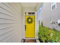 Vibrant yellow front door with a wreath, welcoming entryway, and a charming welcome mat at 9712 Fanning Basket Ln, Ladson, SC 29456