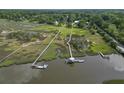 An aerial view shows the home's dock access to the marsh creek and the surrounding neighborhood at 1193 River Rd, Johns Island, SC 29455