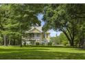 Lovely two-story home surrounded by lush greenery and a well-maintained lawn, creating a serene setting at 1193 River Rd, Johns Island, SC 29455