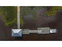 Aerial view showcases a private boat dock with a covered gazebo and boat slip amidst a scenic marsh landscape at 1227 River Rd, Johns Island, SC 29455