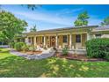 Inviting single-story home features a charming front porch with stately columns and meticulous landscaping enhancing its curb appeal at 1227 River Rd, Johns Island, SC 29455