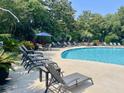 Relaxing pool area with lounge chairs and shade umbrellas at 1300 Park West Blvd # 822, Mount Pleasant, SC 29466