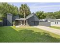 Charming modern home with gray siding, a two-car garage, long driveway and a beautiful palm tree at 1368 Little David Court Ct, Charleston, SC 29412