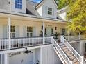Detailed view of charming home with a double-decker porch, stairs, and two garage doors at 1491 Greenshade Way, Mount Pleasant, SC 29464