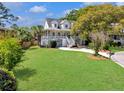 Lush front yard with healthy green grass and a charming white home with a welcoming porch at 1491 Greenshade Way, Mount Pleasant, SC 29464