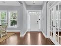 Bright foyer features hardwood floors, a white front door with sidelights, and beautiful french doors at 1523 Nautical Chart Dr, Charleston, SC 29414