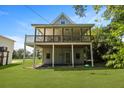 Coastal home with a spacious, shaded porch and a well-manicured lawn, perfect for outdoor living at 1625 Teal Marsh Rd, Charleston, SC 29412