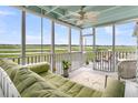 Relaxing screened porch offers comfortable seating and beautiful marsh views at 250 Little Oak Island Dr, Folly Beach, SC 29439