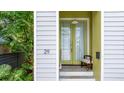 A close-up of the home's entrance, which showcases the front door, number and a charming chair at 29 Hanover St, Charleston, SC 29403