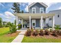 Inviting front porch with stylish seating, decorative plants, and white columns, perfect for relaxing outdoors at 290 Woodland Oak Way, Summerville, SC 29485