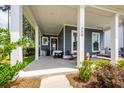 Close-up of the spacious covered porch with comfortable seating and attractive details at 290 Woodland Oak Way, Summerville, SC 29485