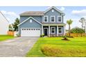 Charming two-story home exhibiting manicured lawn, blue siding, and a well-lit two car garage and driveway at 3010 Grinnell St, Johns Island, SC 29455
